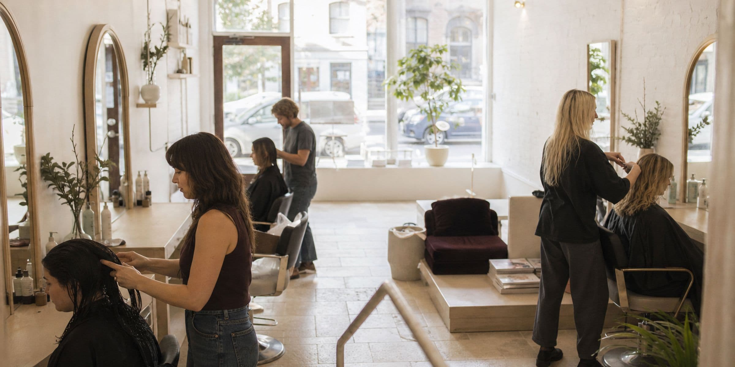 The salon team at work, seen from the doorway in soft daylight.